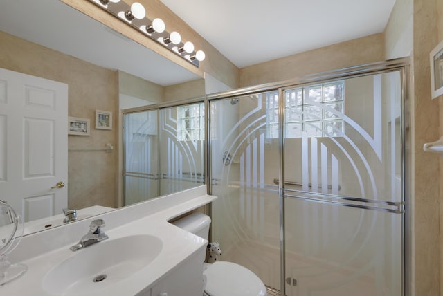 bathroom featuring toilet, a shower with door, and vanity