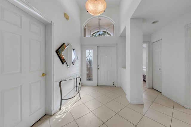 entrance foyer with a towering ceiling and light tile patterned flooring