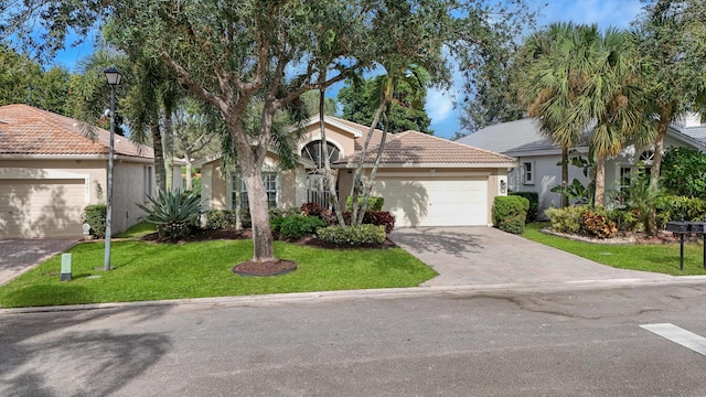 mediterranean / spanish-style house featuring a garage and a front yard