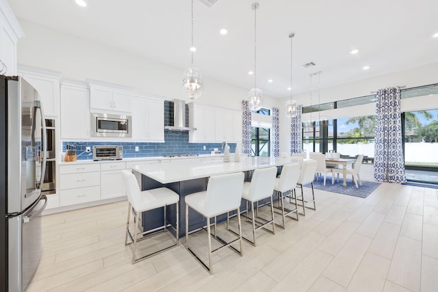 kitchen featuring pendant lighting, stainless steel appliances, and a healthy amount of sunlight