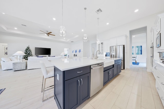 kitchen featuring decorative light fixtures, stainless steel appliances, white cabinetry, and ceiling fan