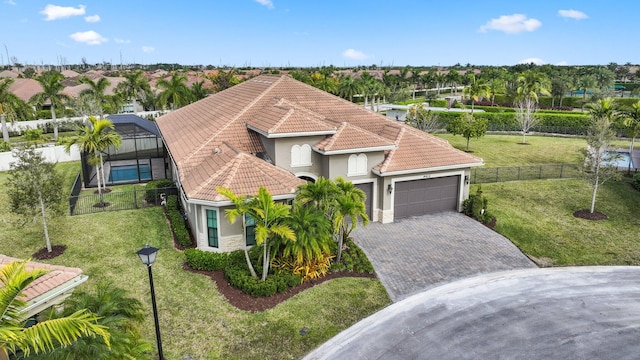 mediterranean / spanish-style home with glass enclosure, a garage, and a front yard