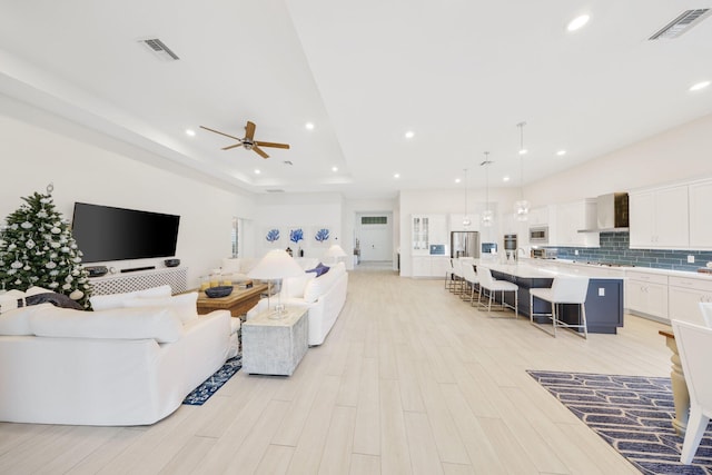 living room with ceiling fan and light wood-type flooring