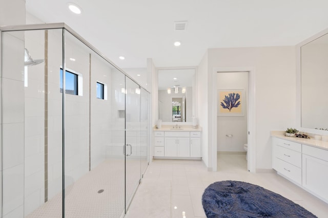 bathroom featuring tile patterned floors, vanity, an enclosed shower, and toilet