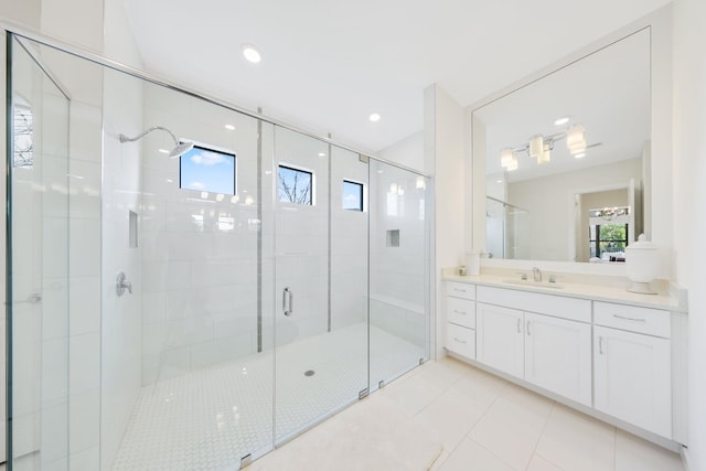 bathroom with tile patterned floors, a shower with door, and vanity