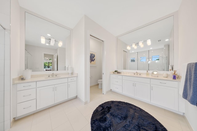 bathroom featuring tile patterned floors, toilet, an enclosed shower, and vanity