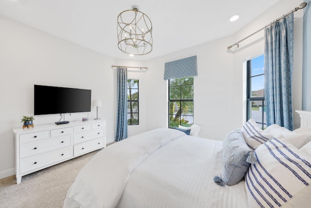 carpeted bedroom with a chandelier and multiple windows