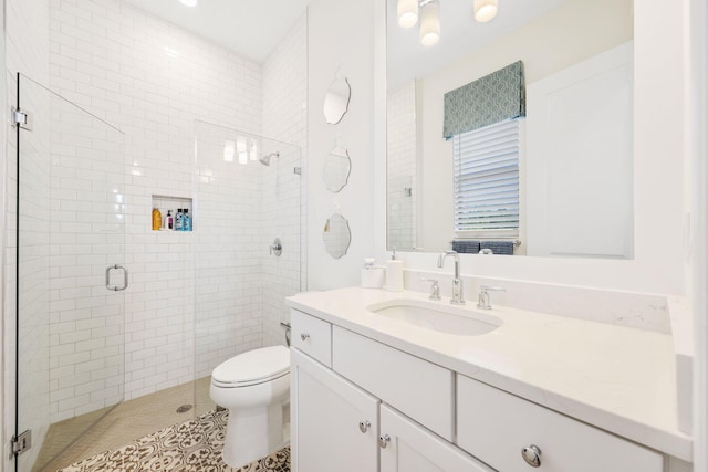 bathroom with tile patterned floors, vanity, an enclosed shower, and toilet