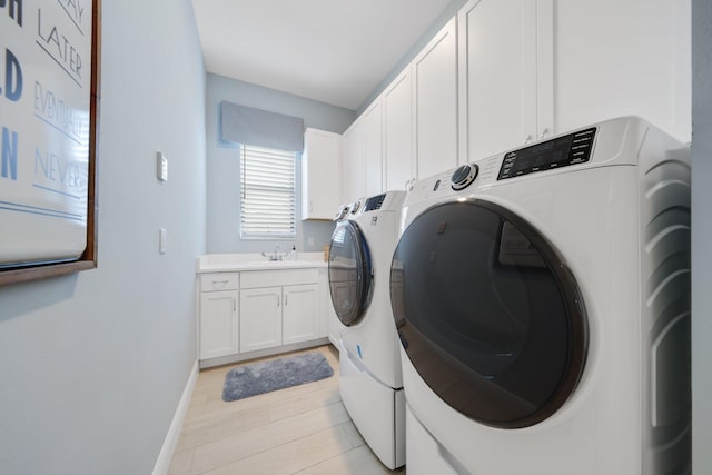 laundry room featuring cabinets, light wood-type flooring, separate washer and dryer, and sink