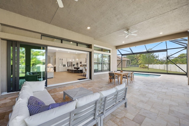 view of patio featuring an outdoor living space, ceiling fan, and glass enclosure