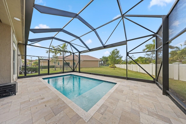 view of swimming pool featuring glass enclosure, a patio area, and a yard