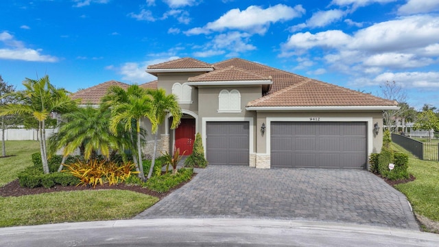 mediterranean / spanish-style house with a garage and a front lawn