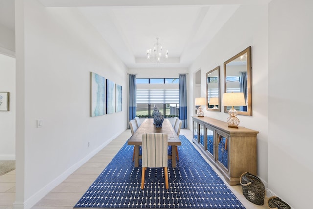 dining space featuring a tray ceiling, a chandelier, and hardwood / wood-style flooring