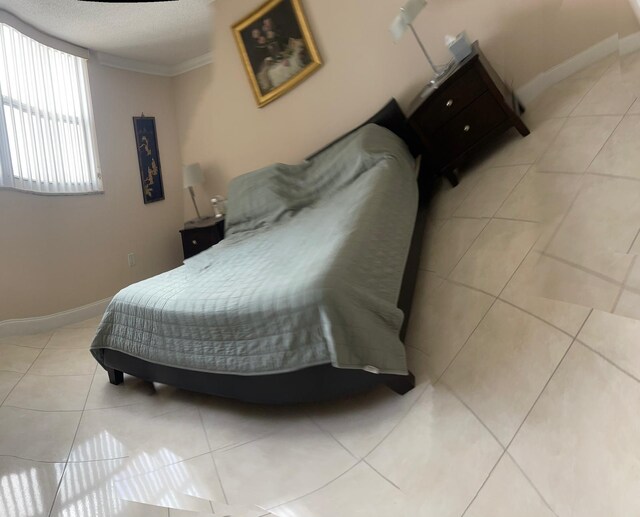 tiled bedroom featuring ornamental molding and a textured ceiling