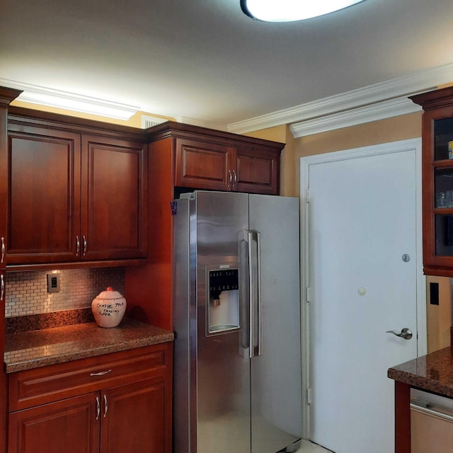 kitchen featuring stainless steel fridge with ice dispenser, tasteful backsplash, crown molding, and dark stone countertops