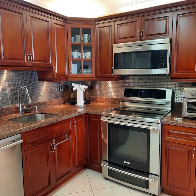 kitchen with decorative backsplash, appliances with stainless steel finishes, light tile patterned floors, and sink