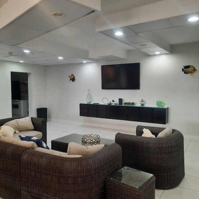 living room with a paneled ceiling and light tile patterned floors