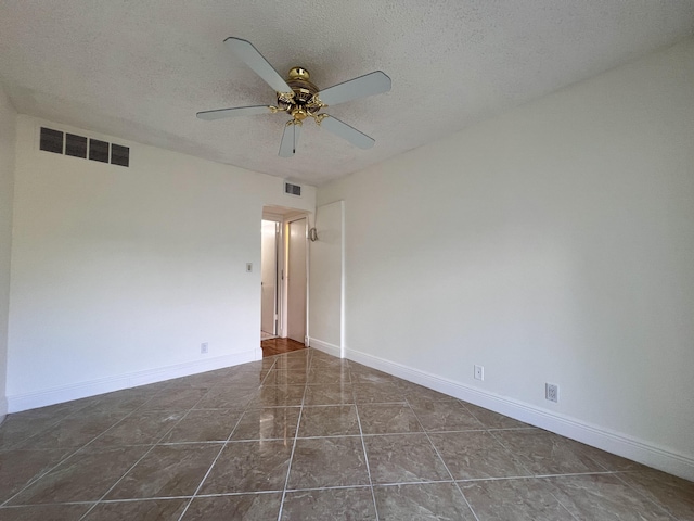 tiled spare room featuring ceiling fan and a textured ceiling