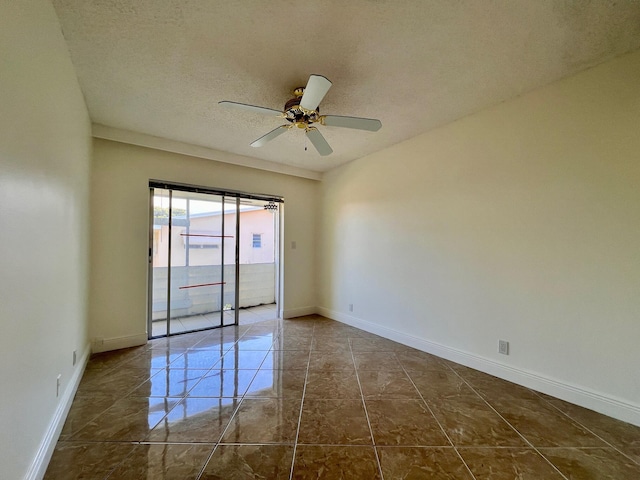 spare room featuring tile patterned flooring, ceiling fan, and a textured ceiling