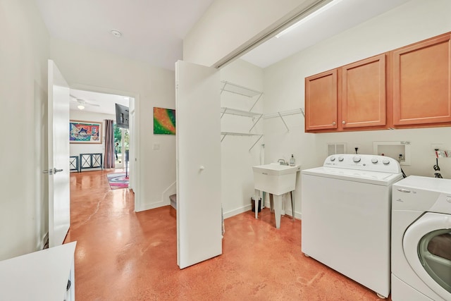 laundry area featuring cabinets, separate washer and dryer, and sink