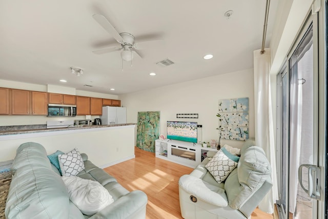 living room with ceiling fan and light hardwood / wood-style floors