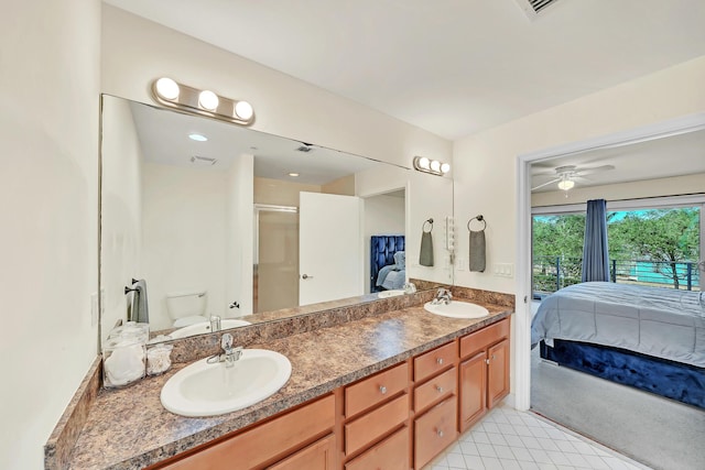 bathroom featuring ceiling fan, toilet, a shower with shower door, and vanity