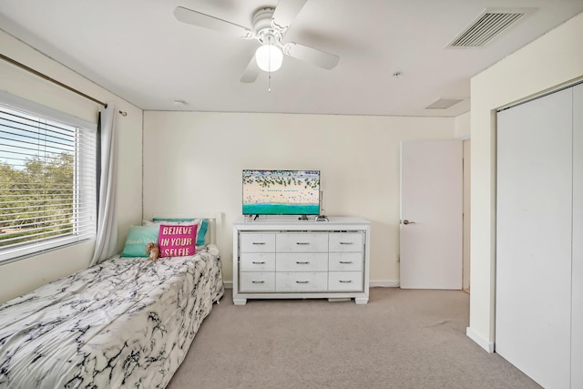 carpeted bedroom featuring ceiling fan and a closet