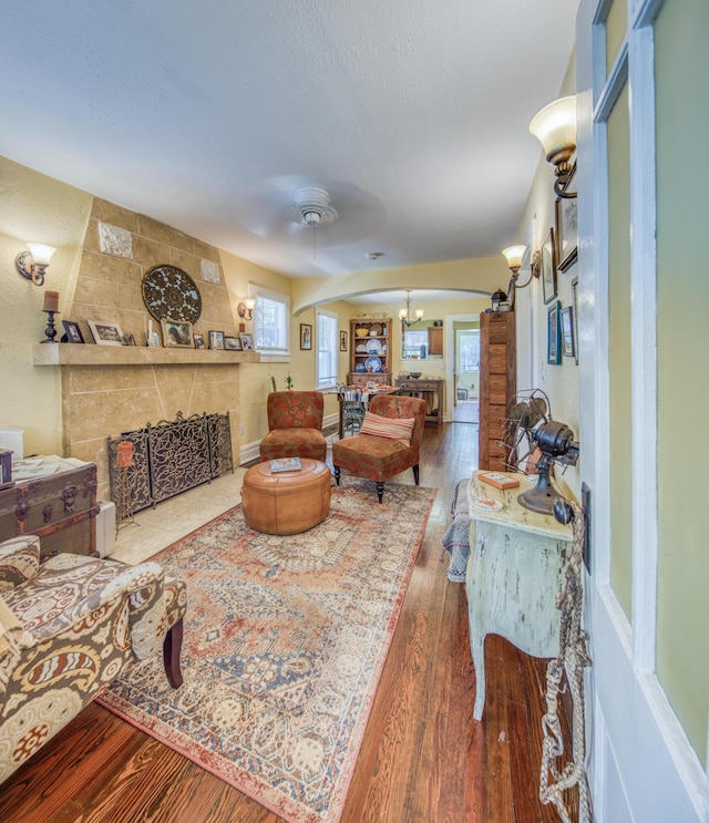 living room with wood-type flooring, ceiling fan with notable chandelier, and vaulted ceiling