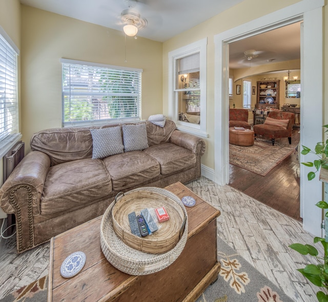 living room featuring light hardwood / wood-style floors and ceiling fan with notable chandelier