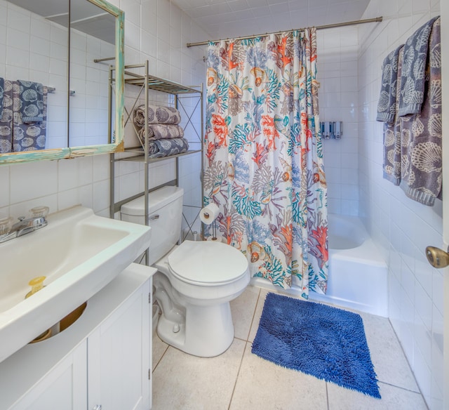 full bathroom with tile patterned flooring, shower / bath combination with curtain, toilet, vanity, and tile walls