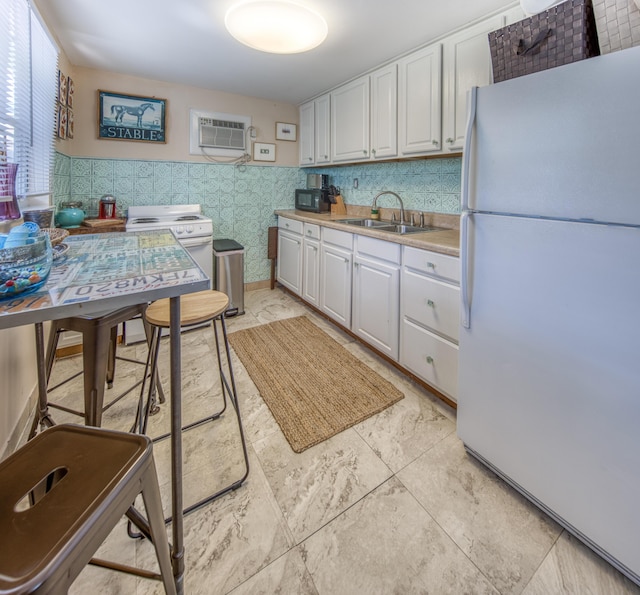 kitchen with white cabinets, white appliances, a wall mounted AC, and sink