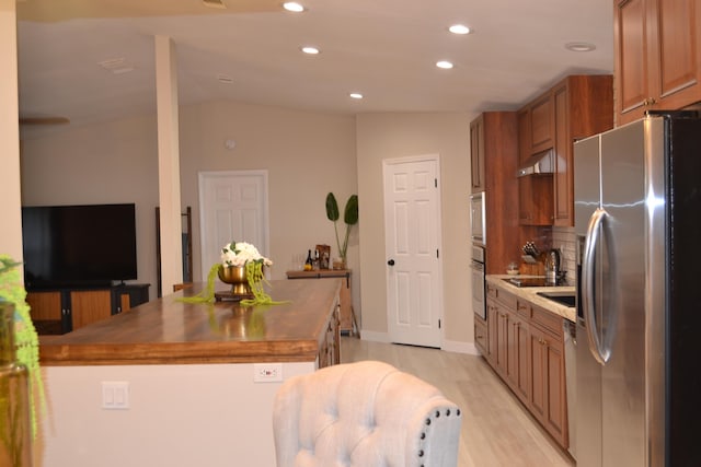 kitchen with lofted ceiling, backsplash, wooden counters, appliances with stainless steel finishes, and light hardwood / wood-style floors