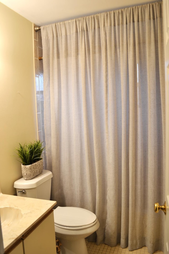 bathroom with tile patterned floors, walk in shower, vanity, and toilet