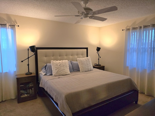 bedroom with carpet, a textured ceiling, and ceiling fan