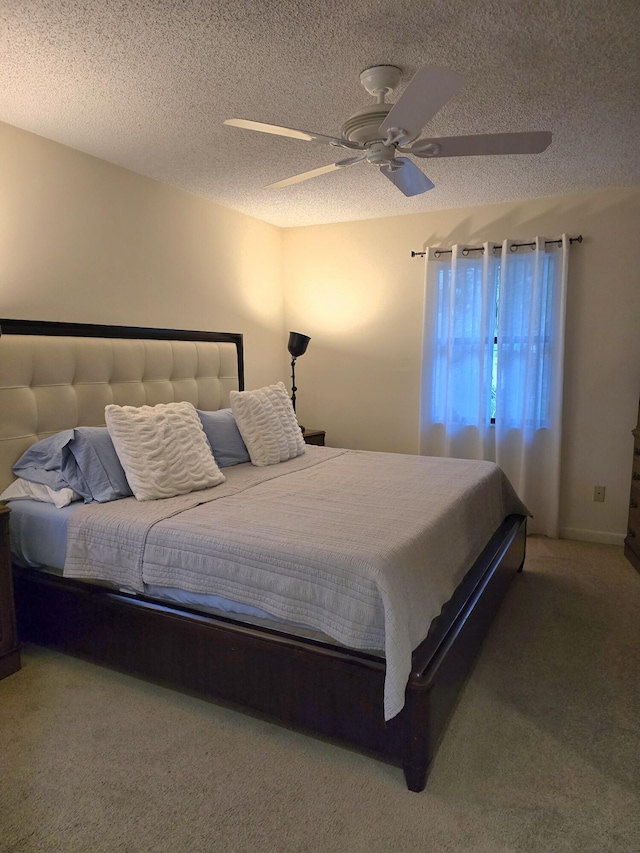 carpeted bedroom featuring ceiling fan and a textured ceiling