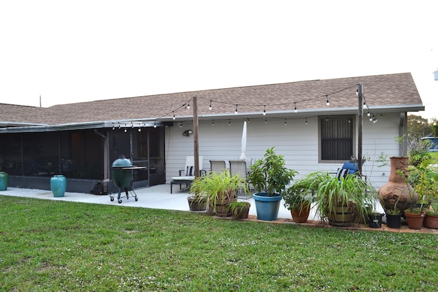 rear view of house featuring a lawn, a patio area, and a sunroom