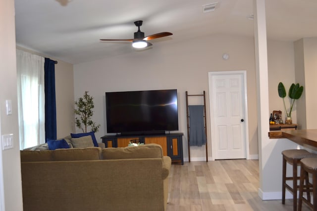 living room with light hardwood / wood-style floors, ceiling fan, and lofted ceiling