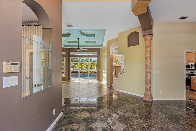 interior space with ceiling fan and decorative columns