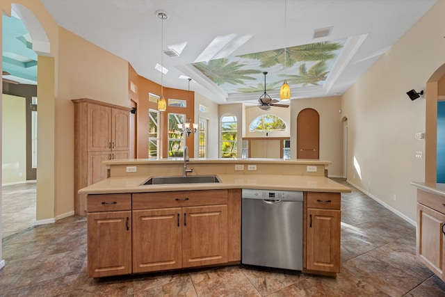 kitchen featuring ceiling fan, sink, hanging light fixtures, stainless steel dishwasher, and a center island with sink