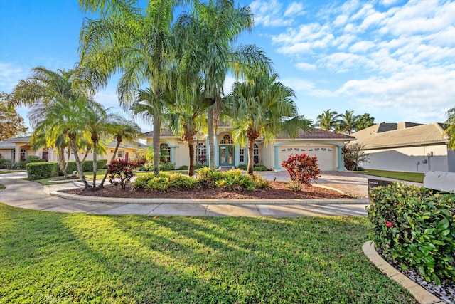 mediterranean / spanish house with a front yard and a garage