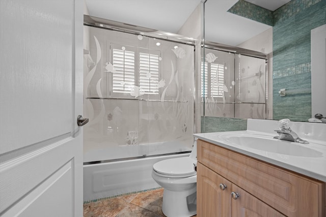 full bathroom featuring tile patterned flooring, vanity, toilet, and bath / shower combo with glass door