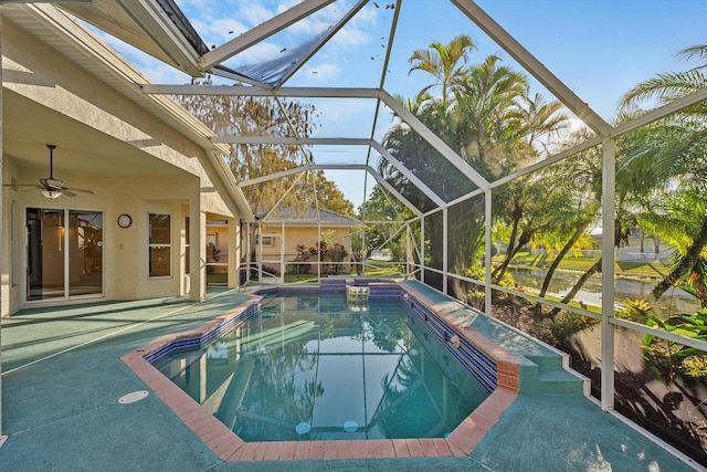 view of pool featuring a patio, glass enclosure, and ceiling fan