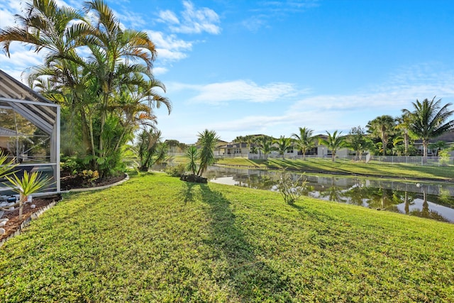 view of yard with a water view and glass enclosure