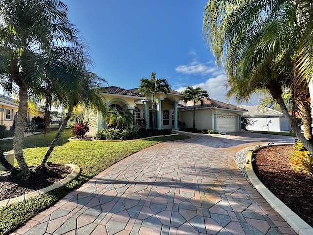 mediterranean / spanish-style house with a front yard and a garage