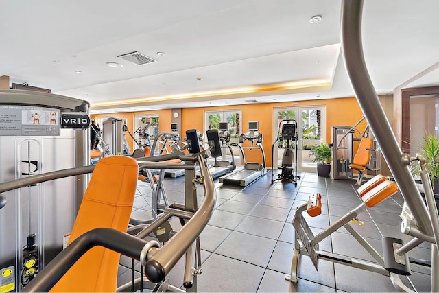 gym featuring a raised ceiling