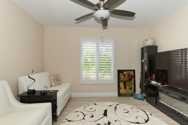 living area with ceiling fan and light hardwood / wood-style floors