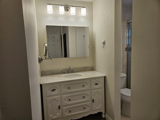 bathroom featuring vanity, toilet, and walk in shower