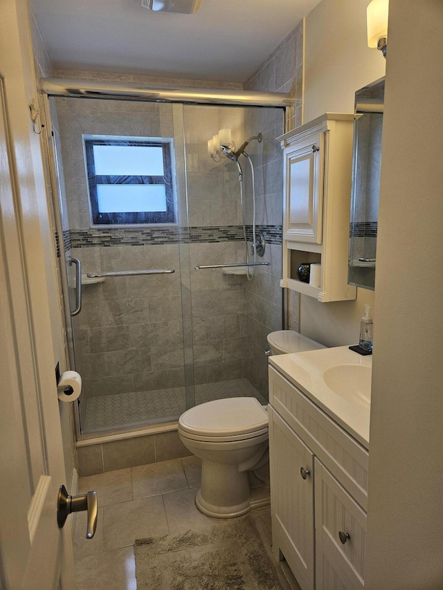 bathroom featuring tile patterned flooring, vanity, toilet, and an enclosed shower