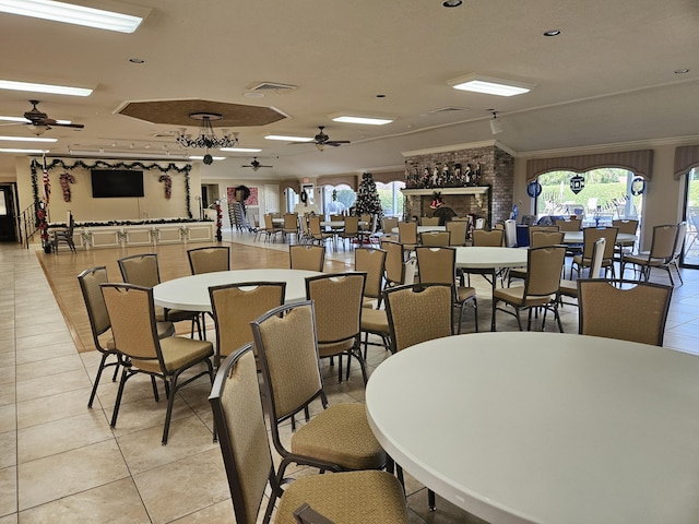 tiled dining room with ceiling fan and ornamental molding