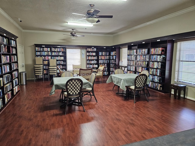 dining area featuring dark hardwood / wood-style flooring, a textured ceiling, ceiling fan, and ornamental molding